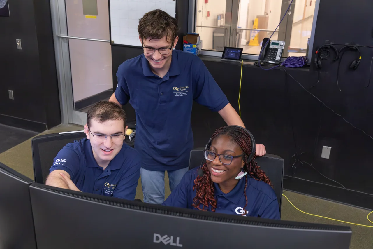 Georgia Tech graduate students Ryan McKee, Andrew Basin and Nina Otebele at the Space Systems Design Laboratory's mission control on campus