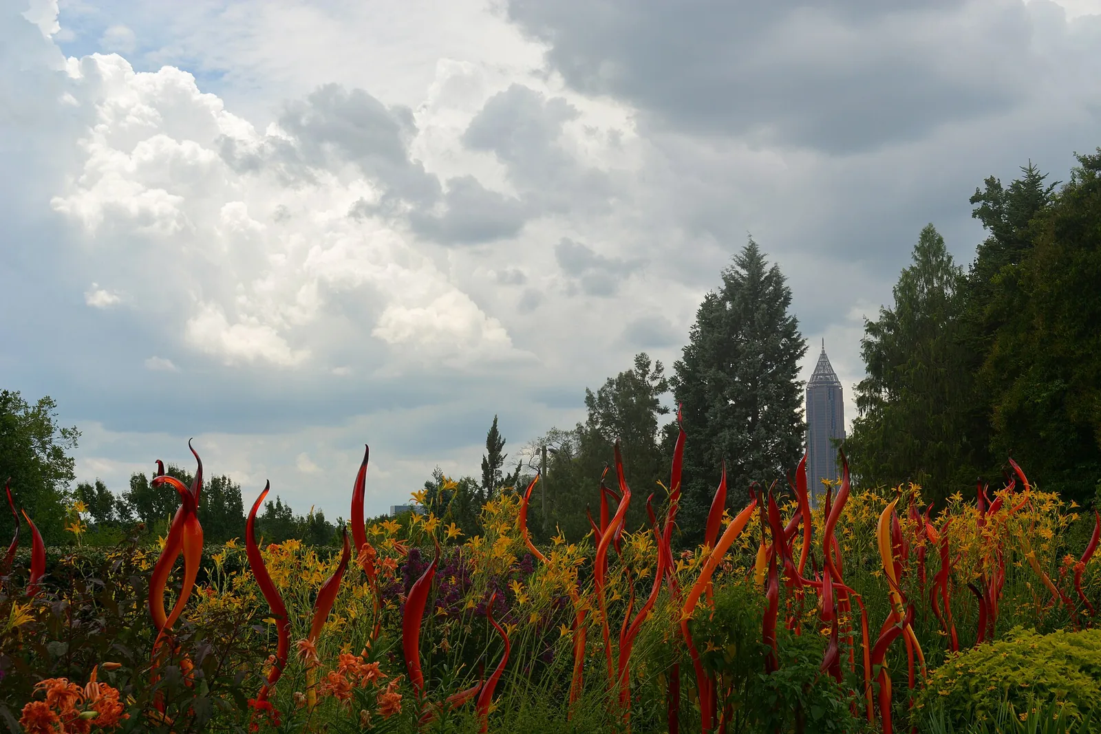 Chihuly glass among the summer flowers at the Atlanta Botanical Garden, with Midtown's Bank of America Plaza behind.